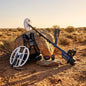 Metal detector and accessories on a rock in a desert setting