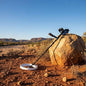 Metal detector on a rock in a desert landscape with mountains in the background